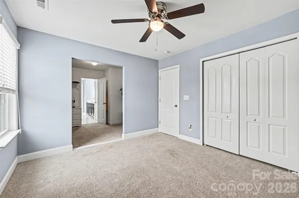 a bed sitting in a bedroom next to a window