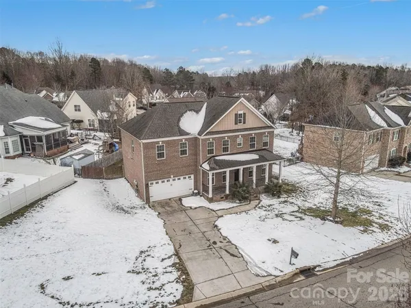 a house with trees covered with snow in front of house