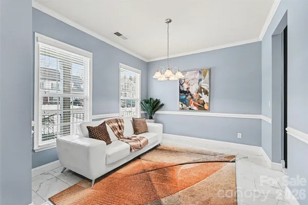 a living room with furniture and a chandelier