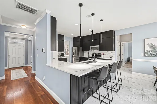 a kitchen with a sink and chairs