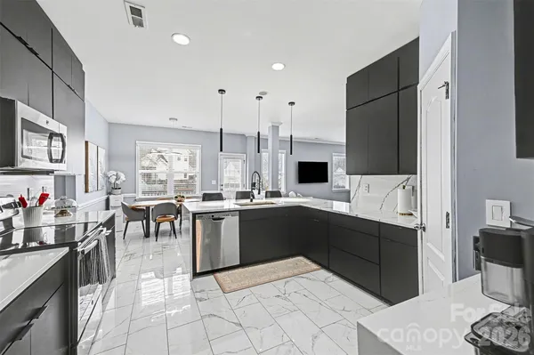 a kitchen with stainless steel appliances kitchen island granite countertop a sink and cabinets