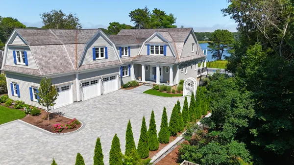 a white house with a yard and large trees