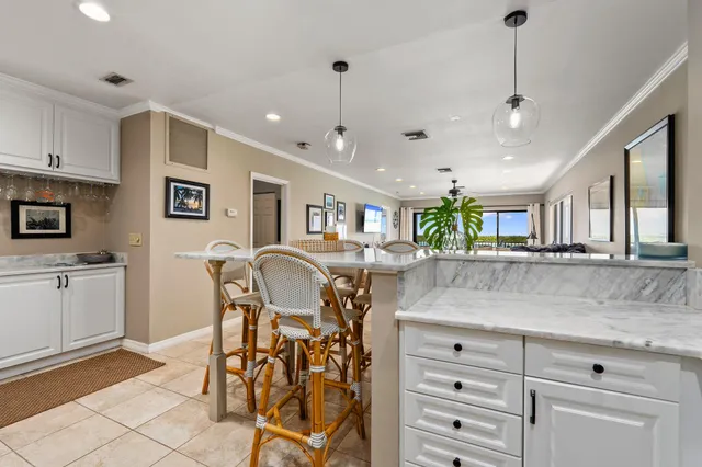 a kitchen with granite countertop white cabinets and window