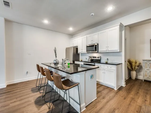 a spacious bathroom with sinks and a wooden floor