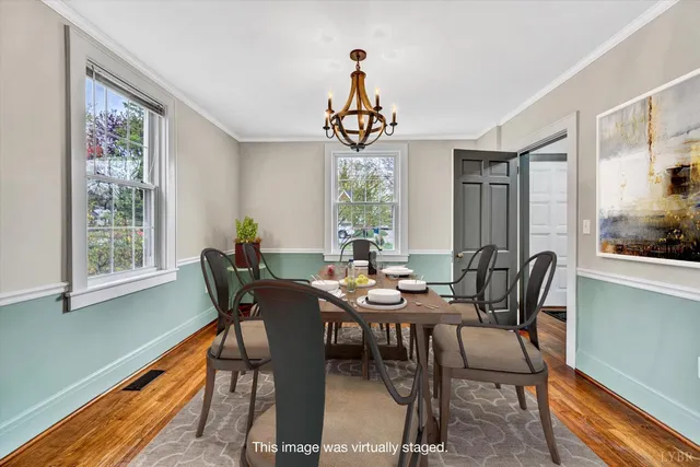 a dining room with furniture a chandelier and wooden floor