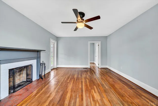 a view of empty room with wooden floor and fireplace