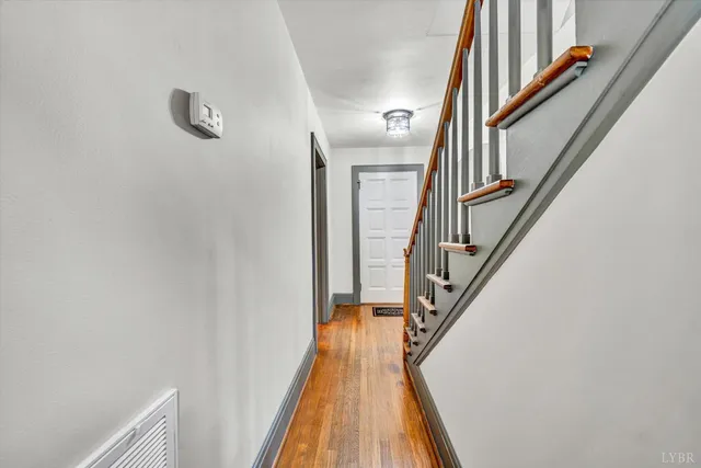 a view of a hallway with wooden floor and staircase