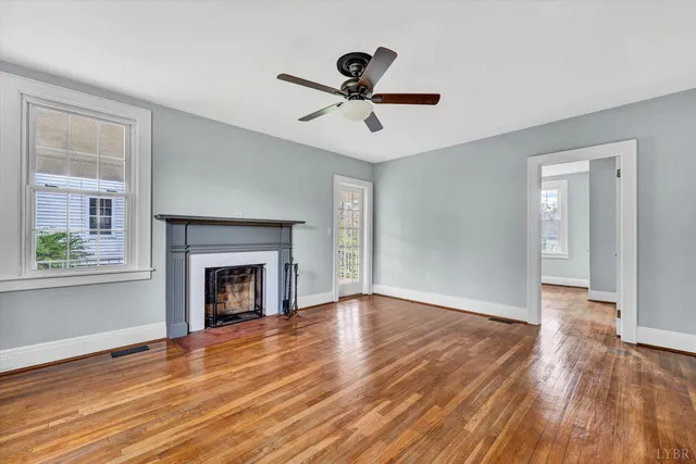 a view of empty room with wooden floor and fireplace