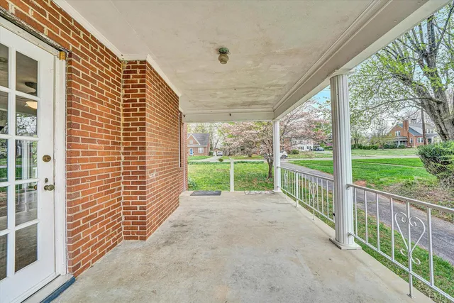 a view of a porch with wooden floor and roof with a floor to ceiling window