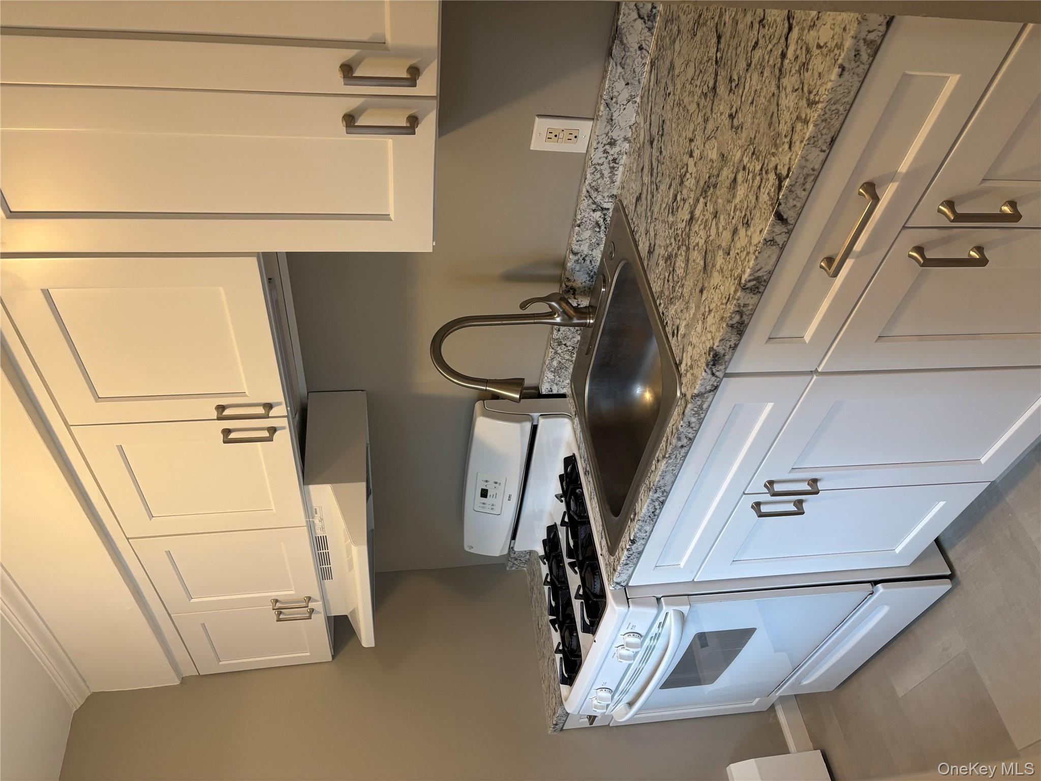 43 Tanager Road, Unit 4303 Monroe, NY 10950 - Photo 3 of 9 Kitchen with white stove, white cabinetry, ventilation hood, and light stone counters