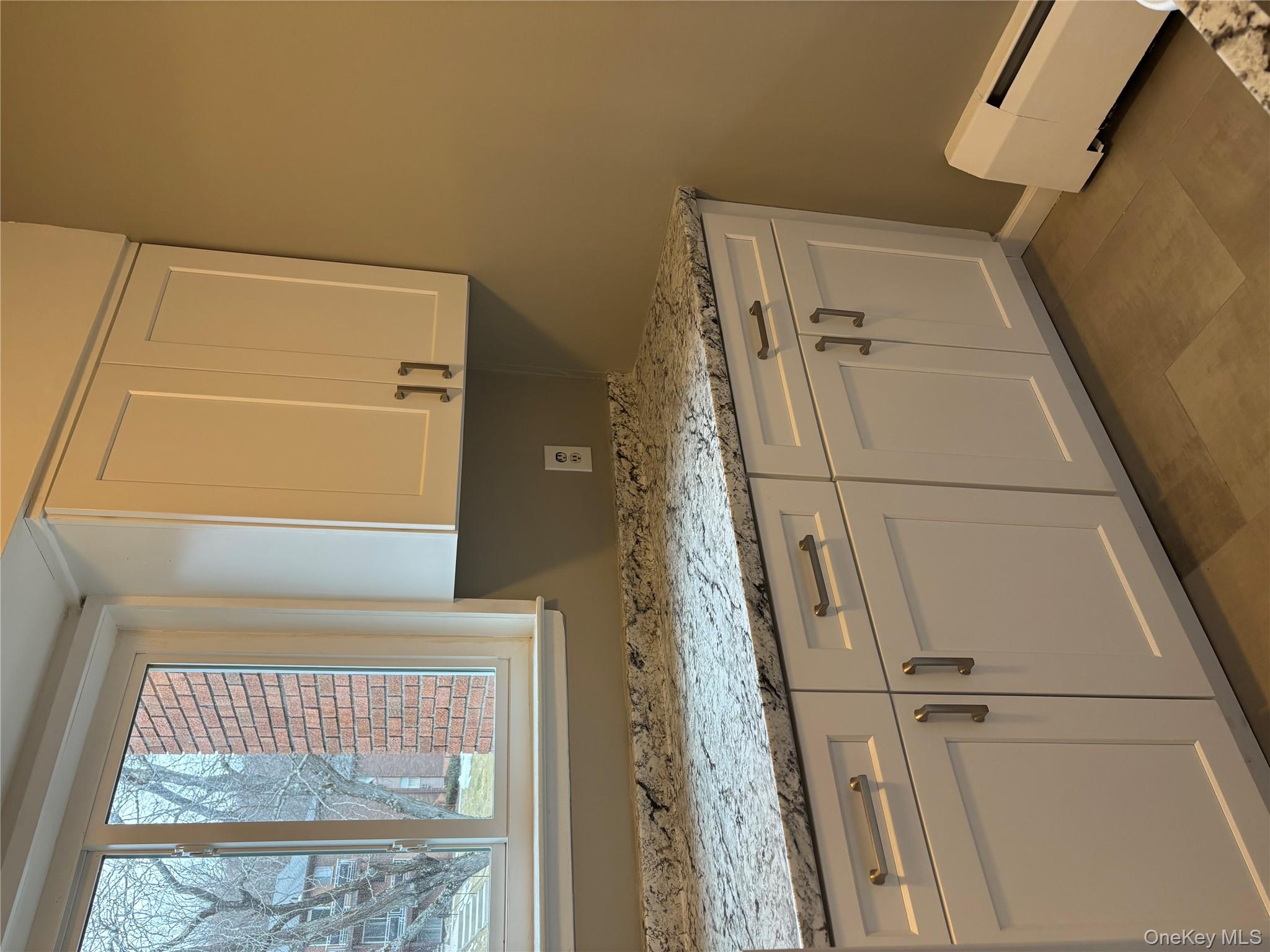 43 Tanager Road, Unit 4303 Monroe, NY 10950 - Photo 4 of 9 Kitchen with light stone countertops, white cabinetry, and baseboard heating