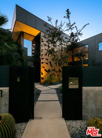 a front view of a house with a tree