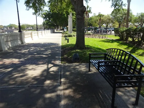 a view of a bench in the garden near a lake