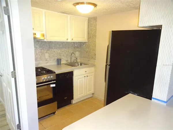 a kitchen with a refrigerator and a sink