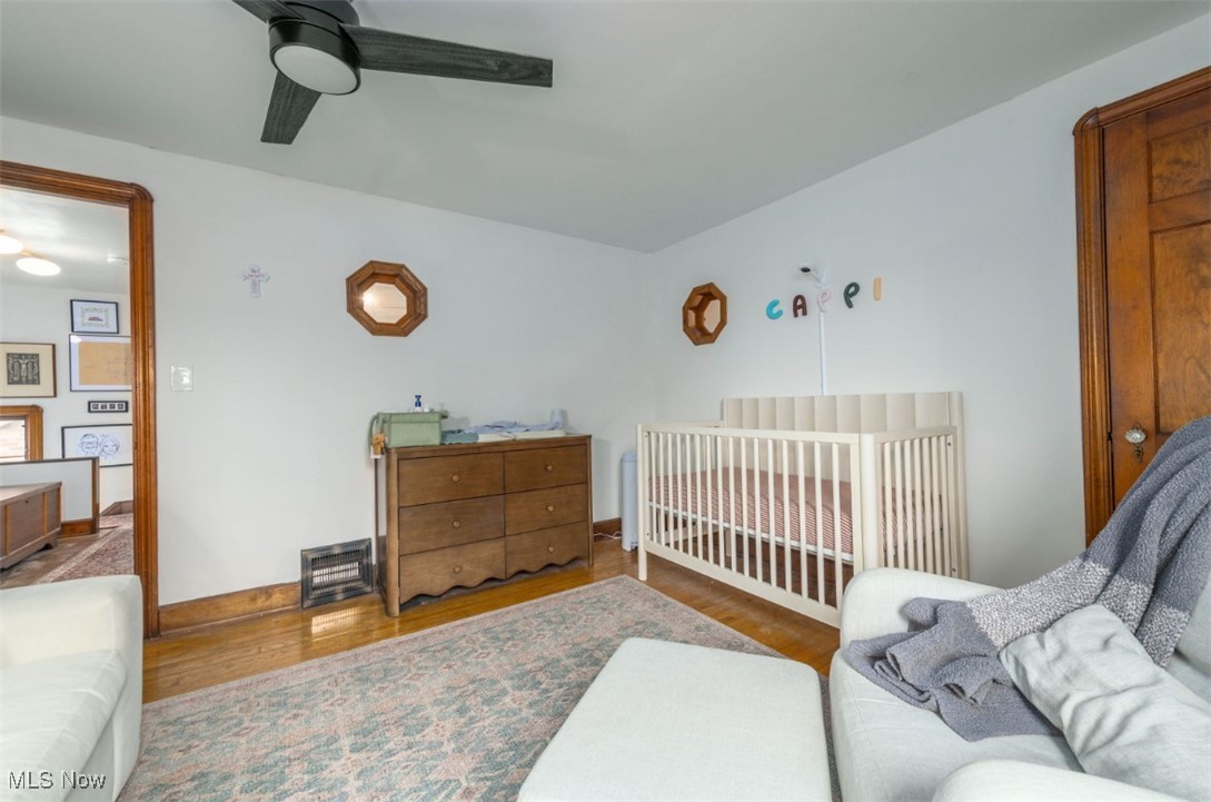 15500 Greenway Road Cleveland, OH 44111 - Photo 27 of 36 Bedroom with a nursery area, a ceiling fan, and wood finished floors
