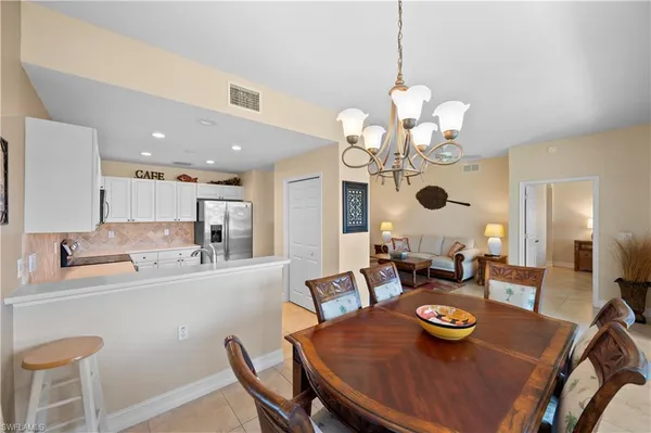 a dining room with wooden floor a chandelier a wooden table and chairs