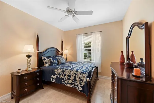 a bedroom with a bed and a dresser with the mirror