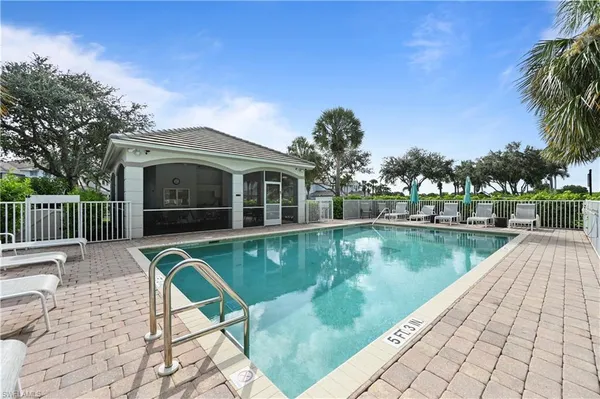 a view of house with swimming pool and outdoor seating