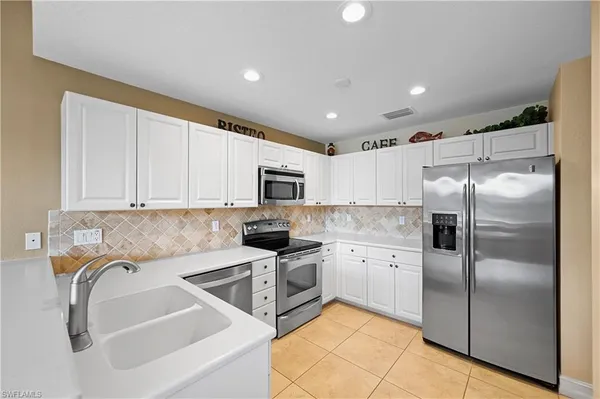 a kitchen with stainless steel appliances granite countertop a sink a stove and a refrigerator