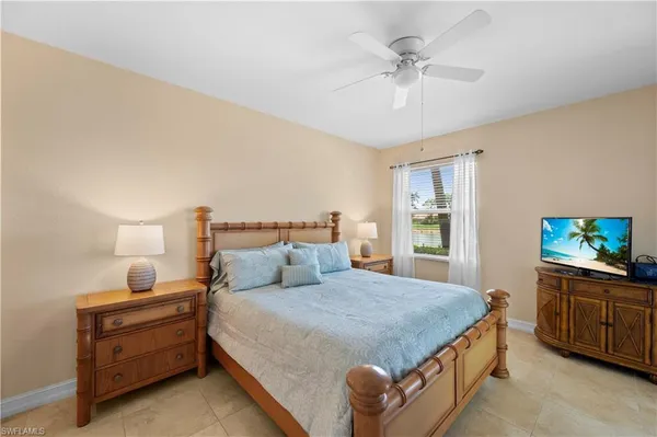 a bedroom with a bed and a flat tv screen on dresser