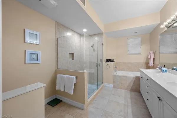 a bathroom with a tub a sink and mirror