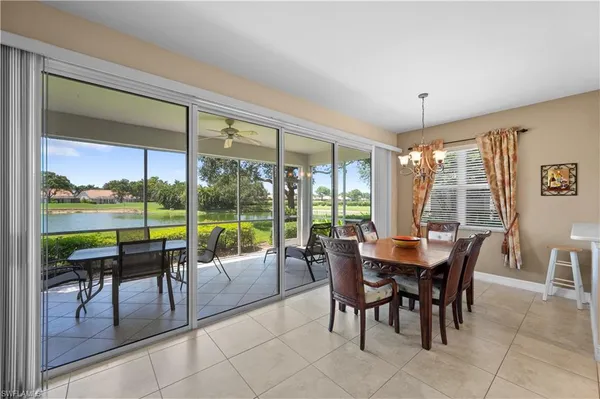a dining room with furniture and large windows