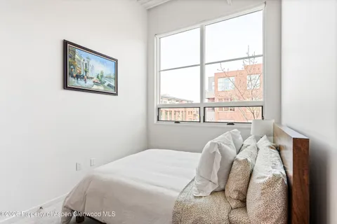 a bed sitting in a bedroom next to a window