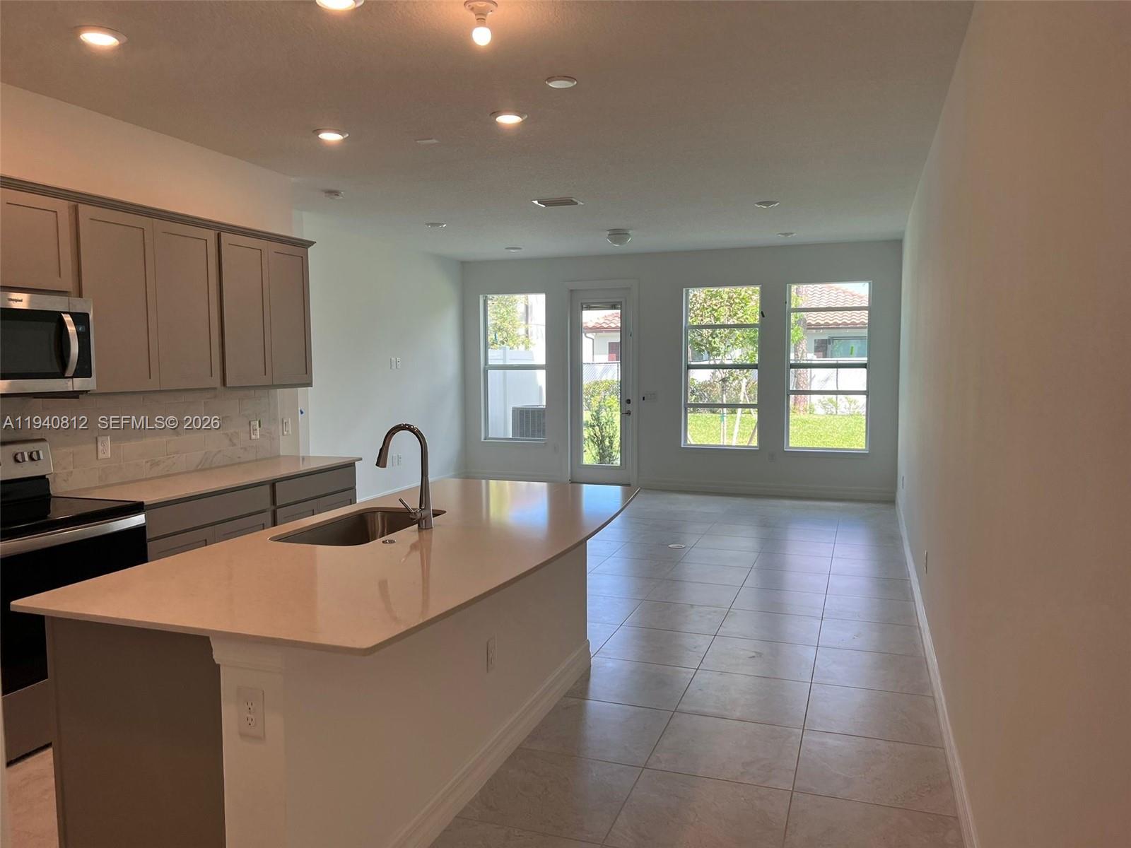 6121 Rancho Lane Greenacres, FL 33415 - Photo 2 of 17 a kitchen with a sink and a refrigerator