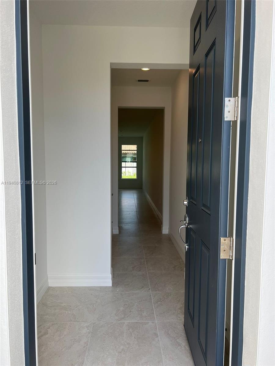 6121 Rancho Lane Greenacres, FL 33415 - Photo 5 of 17 a view of a hallway with wooden shelves