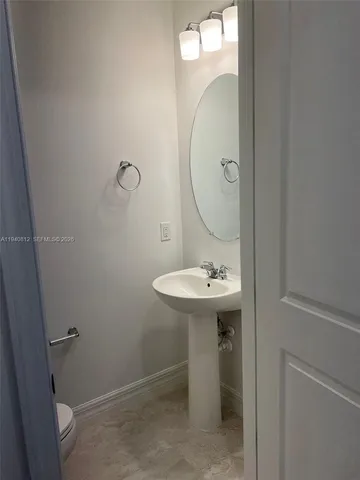 a bathroom with a sink a toilet and mirror