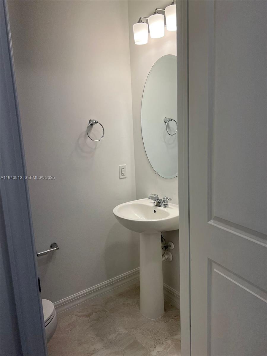 6121 Rancho Lane Greenacres, FL 33415 - Photo 7 of 17 a bathroom with a sink a toilet and mirror