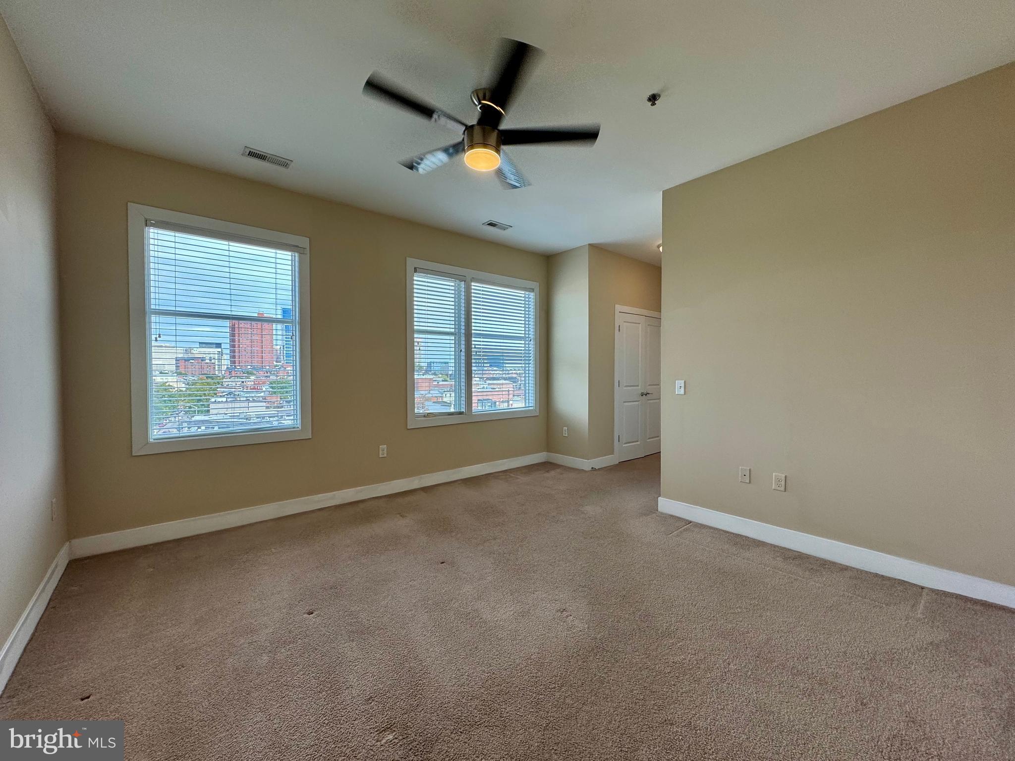 1201 South Charles Street, Unit 5A Baltimore, MD 21230 - Photo 11 of 15 an empty room with windows and ceiling fan