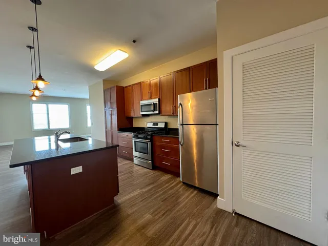 a kitchen with refrigerator cabinets and wooden floor