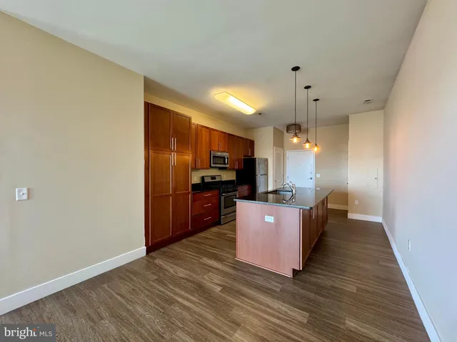 a living room with hard wood floors and a kitchen