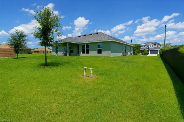 a backyard of a house with table and chairs