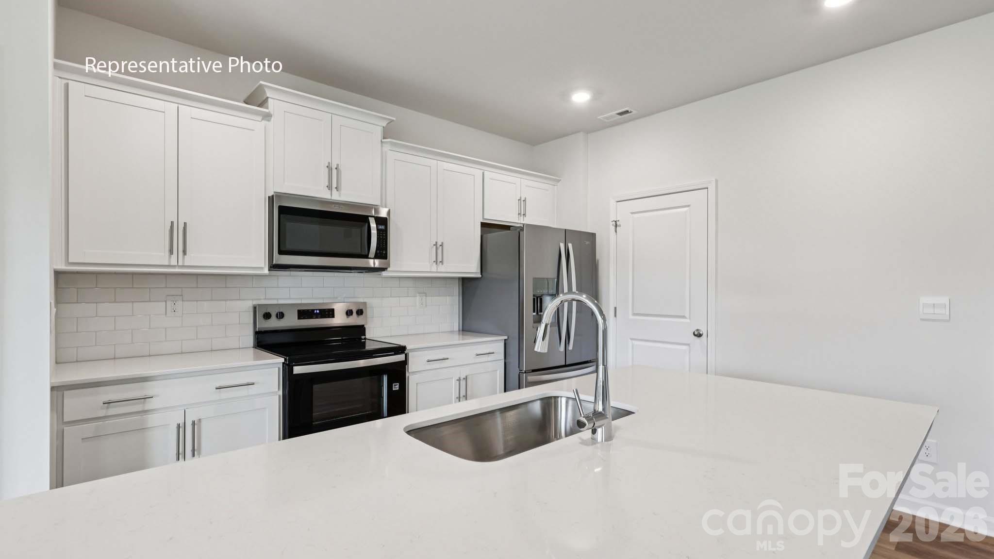 7608 Bainbridge Road Sherrills Ford, NC 28673 - Photo 12 of 28 a kitchen with a sink a stove a microwave and cabinets