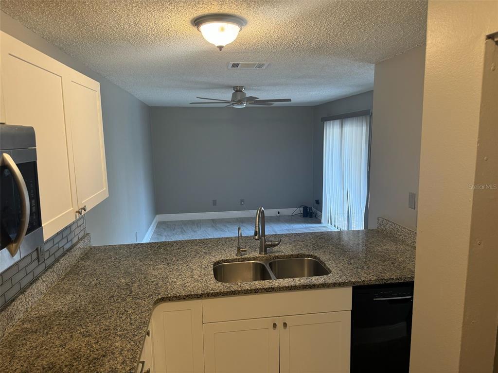 1030 Abada Court Northeast, Unit 110 Palm Bay, FL 32905 - Photo 9 of 14 a kitchen with a sink and cabinets