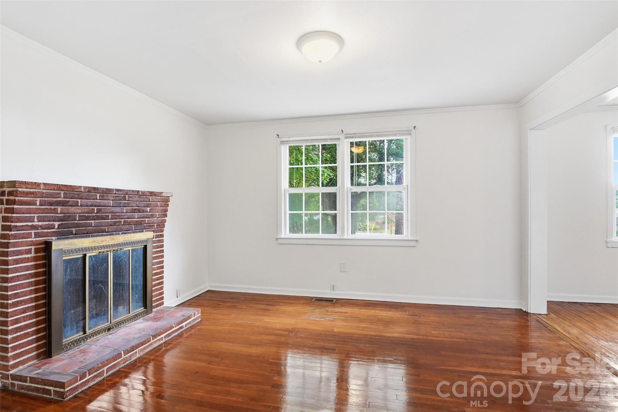 128 Ella Street Chester, SC 29706 - Photo 14 of 18 a view of an empty room with wooden floor fireplace and a window