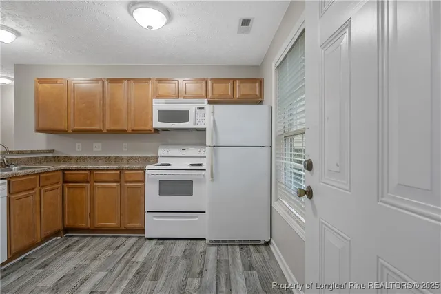 a kitchen with a white cabinets and white appliances