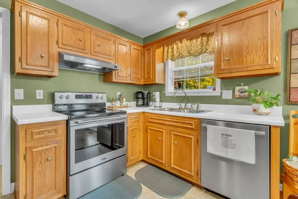 a kitchen with stainless steel appliances granite countertop a stove and a white cabinets