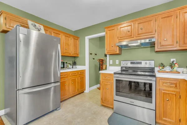 a kitchen with stainless steel appliances granite countertop a refrigerator a stove and a sink