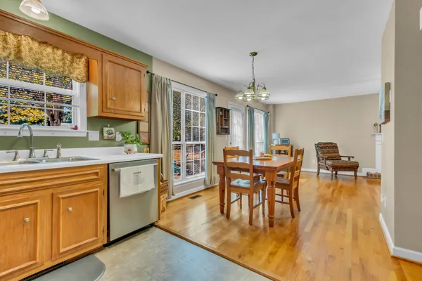 a dining hall with couches a dining table and chairs with wooden floor