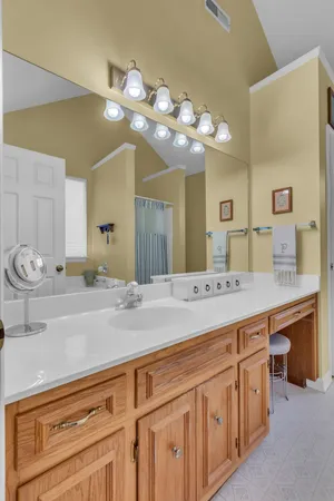 a bathroom with a sink a vanity and lamp