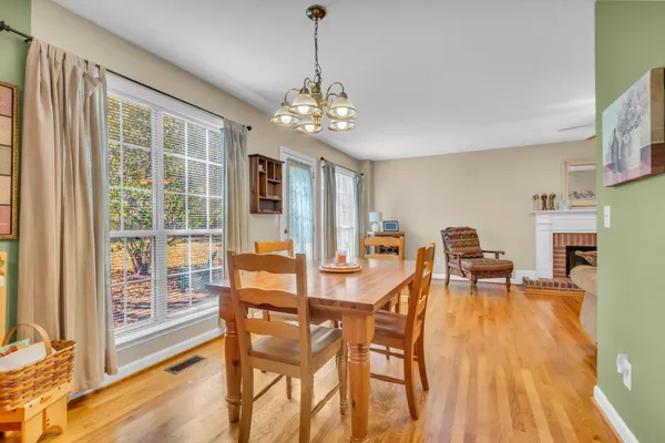 a dining room with furniture a chandelier and wooden floor