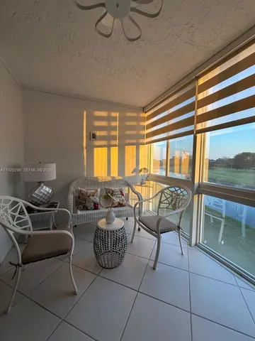a living room with furniture and a floor to ceiling window