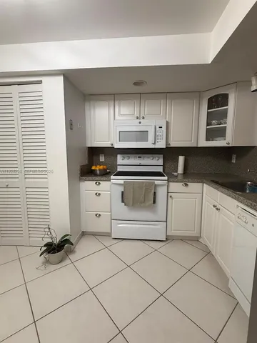 a white kitchen with a sink and cabinets