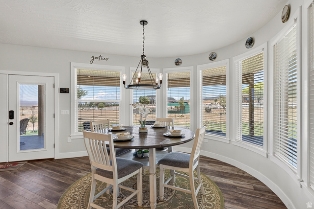 3311 West Allard Summit, UT 84772 - Photo 22 of 97 Dining area featuring a curved wall of multiple windows with horizontal blinds, a glass-paned door, wood-finish flooring, and a modern chandelier