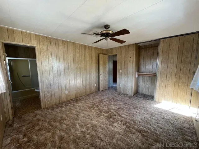 a view of empty room with a kitchen