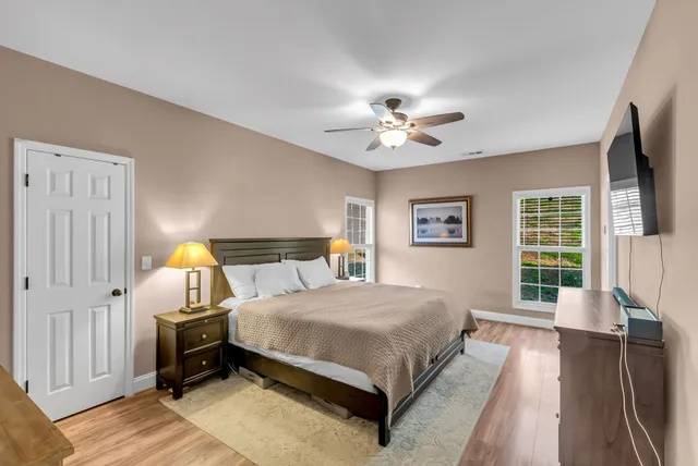 a bedroom with a bed chandelier and a window