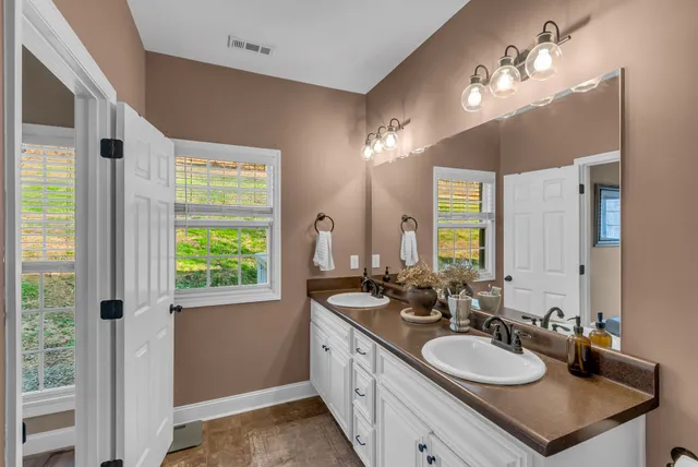 a bathroom with a double vanity sink and a mirror